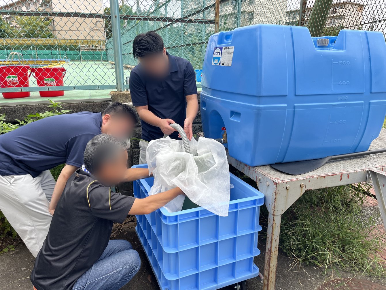 給水タンクからコンテナへ水を汲み上げる作業の様子