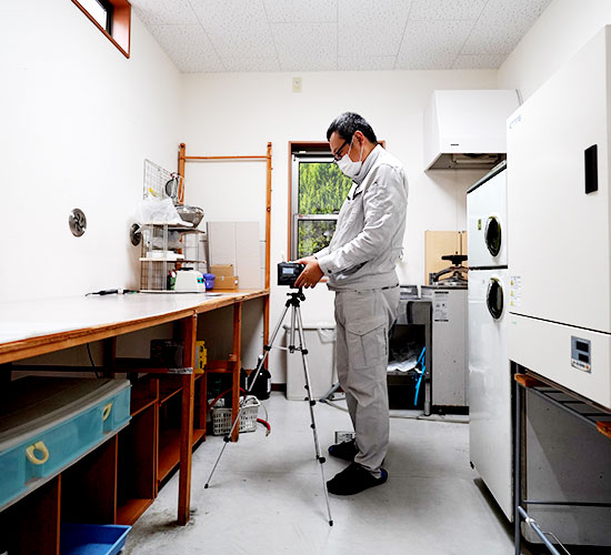 個人ばく露測定講習（デザイン等講習）を修了した当社スタッフが、お客様の作業場で測定機器を設置している様子
